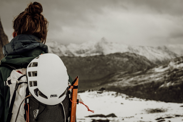 Helm en pickel op rugzak in de bergen
